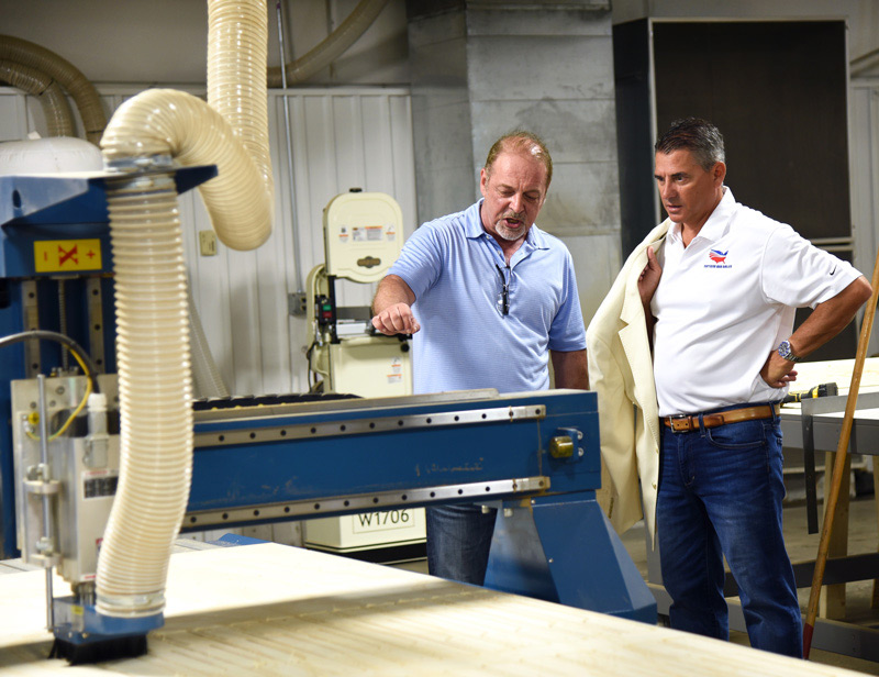 Founder Vern Kauffman (left) gives Chip Osborne of Nation’s Bus a tour of L.A. West’s new production facility